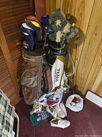 Two golf bags with assorted clubs, women's golf shoes, balls and tees