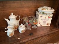 Photo showing Royal Worcester Evesham Irish coffee glasses, original boxed set, lidded Royal Worcester serving dish, and Kaiser coffee pot set including cream and sugar bowl, all with fruit pattern decoration.