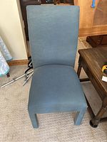 Front view of the blue fabric upholstered chair showing the seat and backrest.