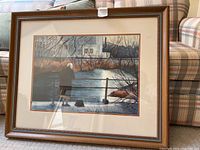 Full front view of framed watercolor showing winter landscape and figure by riverbank
