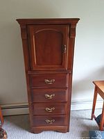 Full front view of solid wood tall boy dresser with cabinet door and drawers