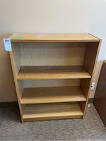 Front view of wood bookcase showing internal adjustable shelves and overall shape.