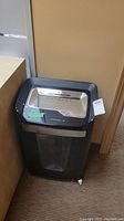 Front top view of Staples paper shredder showing control panel, paper feed slot, and green label with dimensions 16x12x26
