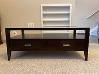 Front view of the Baker cocktail table showing two drawers and glass top.