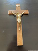 Wood crucifix with brass-colored Jesus figure mounted on a wooden cross base