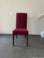 Front view of a high back dining chair with wine-colored slip cover, showing chair shape, color and condition.