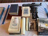 Wide view showing navy books, directories, framed photos, submarine model, binoculars, and DVDs.
