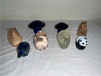 Overview of all eight Orient & Flume art glass pieces arranged on white cloth