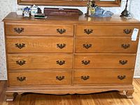 Full frontal view of the solid maple 8 drawer dresser showing warm oak finish and metal drawer pulls.