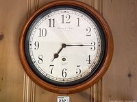 Full front view of the Sterling & Noble wall clock hung on a wooden wall, displaying the entire clock face and frame.