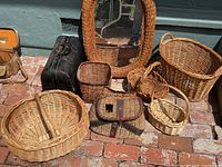 Full view of all baskets, the wicker framed mirror, vintage fishing bag, and old doctor's house call bag