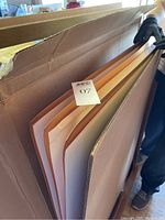 Three large copper-color metal sheets in box, showing overall lot condition.