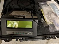 Front view of Fluke Calibration 1529 Chub-E4 unit inside foam-lined case, showing power cable and plastic bag with accessories