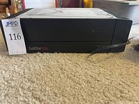 Front view of black Hafler DH-220 amplifier on carpet showing front panel and model branding