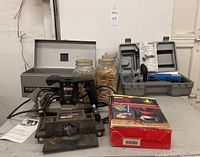 Photo shows entire lot including the Craftsman BisKit Plate Joiner System, three jars of biscuit plates, Porter Cable Model 555 joiner in metal case, Chicago SLB-9100N joiner in blue case, and instruction manuals.