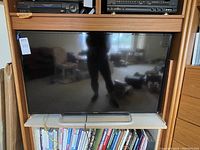Sony Bravia 48" LED TV on stand, screen off, shows reflections.