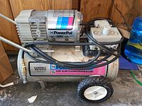 Front and side view of Campbell Hausfeld Power Pal air compressor showing motor, tank, and hoses.