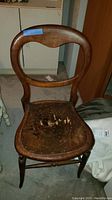 Antique Victorian style balloon back wooden chair showing front view and balloon shape backrest.