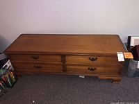 Full view of Lane cedar chest showing top surface, wooden body, brass handles, and legs.