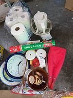 Photo of paper towels, electric pot, clock, aluminum foil, mugs, bowls, and wooden spoon on garage floor