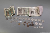 Overview of all paper notes and coins laid out, showing 3 German Reichsbanknotes, 14 Canadian Dollar Coins from 1968-1973, and additional coins of various sizes and metals.