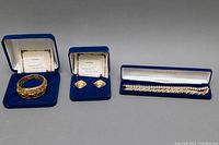 Full set of the jewelry pieces placed side by side in original blue boxes showing earrings, two bracelets, and certificates.