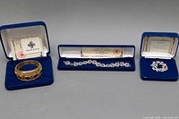 Full set of three jewelry pieces with original blue velvet boxes, certificate, and Camrose & Kross branding.