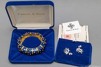Hinged bangle and earrings displayed in original blue velvet Camrose & Kross boxes with COA seen