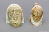 Front view of two Native American miniature stone carvings showing detailed faces