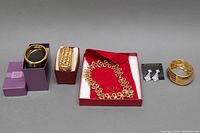 Full lot showing three bangles, one pair of earrings on card, and chunky choker necklace