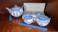 Full set with teapot, creamer, sugar bowl, and 2 saucers displayed with certificate behind