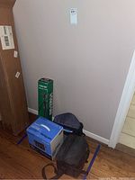 Photo showing boxed Sony Video 8 Handycam, Vanguard tripod box, and black carrying bags on wood floor.