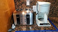 KitchenAid stainless steel 4-slot toaster and white Mr. Coffee coffee maker side by side on counter