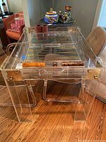 Front angle showing clear acrylic backgammon table with playing surface and chips