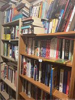 Photo showing two bookcases filled with assorted books including fantasy and cooking books
