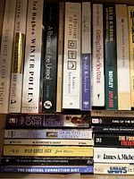 Books shown on a shelf inside a box. Various fiction and non-fiction titles including literature, religious history, and self-help.
