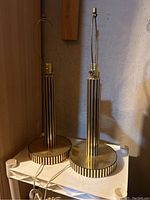 Pair of tall table lamps with black and gold vertical stripes on the base and columns, showing their overall design and size.