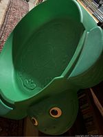 Green turtle-shaped plastic children's sandbox with raised design inside.