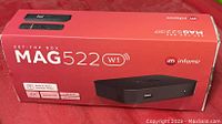 Box of MAG 522 W1 set-top box showing front with product image, specifications including built-in Wi-Fi modem, 4K, Linux OS, 1GB RAM, and 8GB flash.