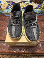Front view of Yeezy Boost 350 V2 sneakers on a shoebox showing overall style and color