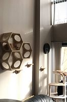 Three unfinished pine wood hexagon cat climbing shelves mounted on wall with three wooden mounting steps below, natural light setting, shows configuration arrangement.