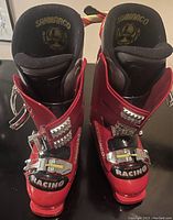 Front view of pair of red Sanmarco Racing alpine ski boots with metal buckles and black lining