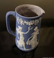 Front and side angle showing classical figures and floral design on jasperware style pitcher