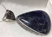 Close-up side view of the blue sodalite stone with silver filigree setting and chain