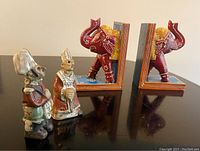 Front view showing both the two Tremar figurines (Bishop and Highland Scottish soldier) and the pair of painted wooden elephant bookends placed behind them.