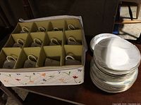 12 teacups in padded fabric storage box with individual compartments for each cup