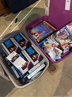 Two bins, one containing Star Trek VHS box sets and tapes, the other Disney trading card packs and dolls in wrappers.