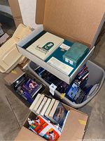 Overview photo showing multiple storage bins filled with Disney VHS tapes, DVDs, and Walt Disney Collectors Society memorabilia.