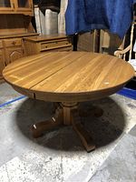 Top view of round oak table inserted with leaf