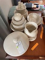Overall view of stacked dishes, casserole, pitcher on table